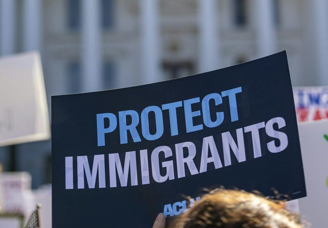 Sign reading 'Protect Immigrants' seen at a protest in front of the California State Capitol in Sacramento.